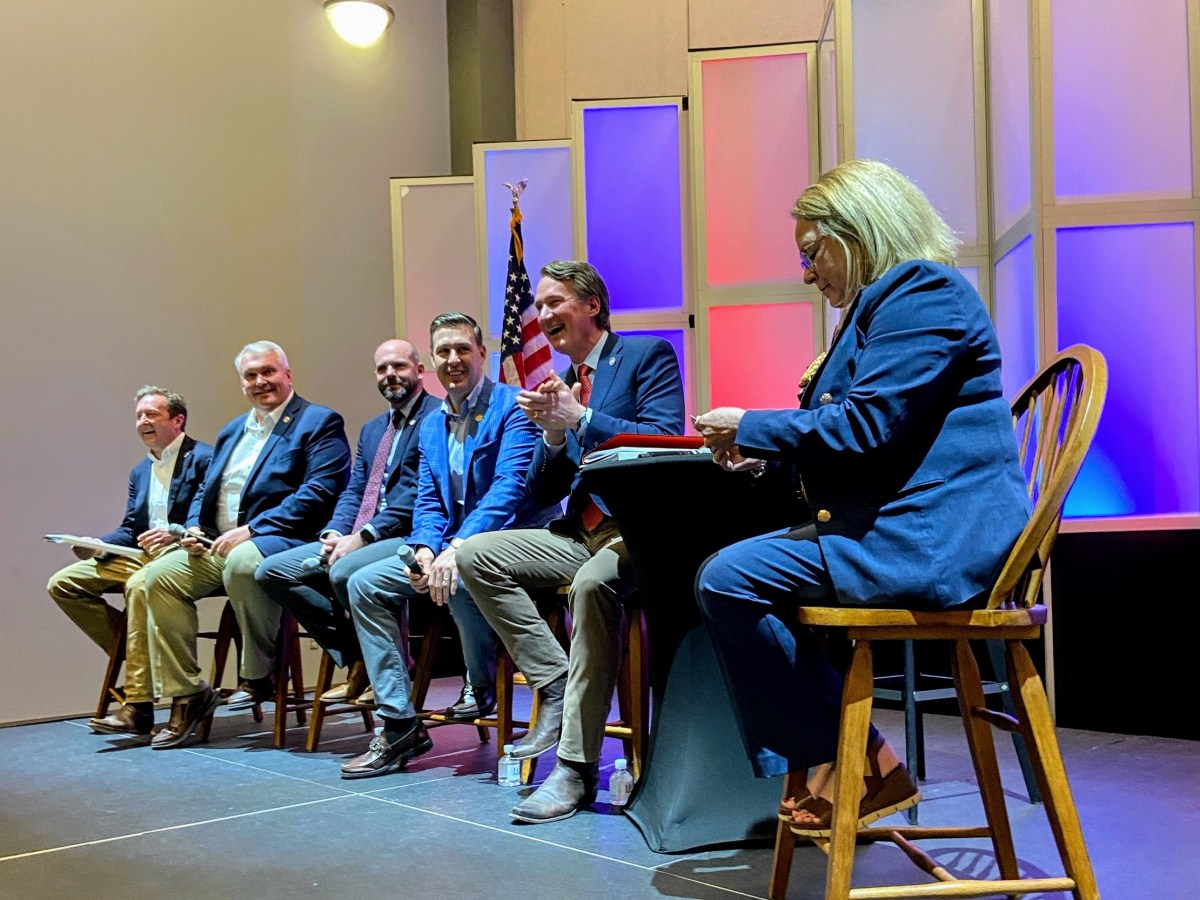Gov. Glenn Youngkin seated on a panel among five other people.