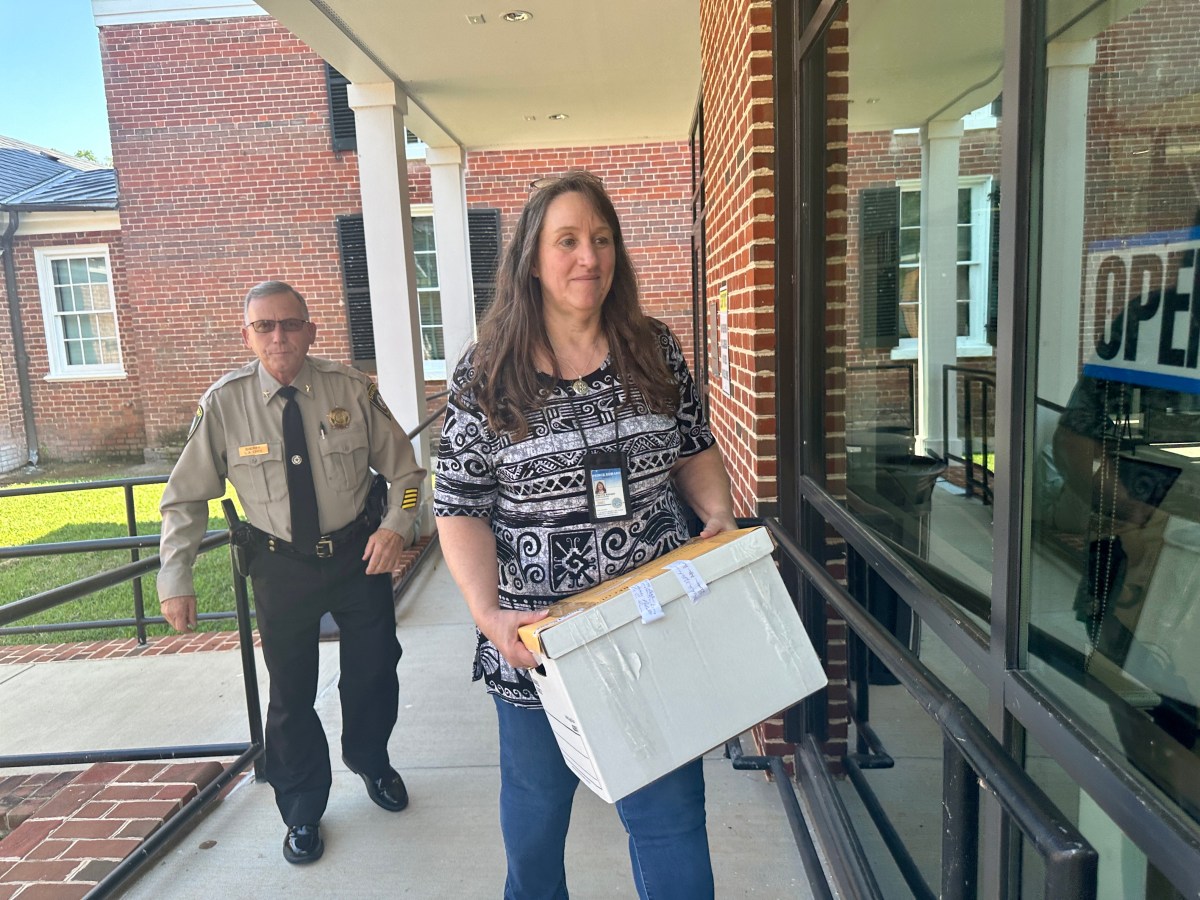 Prince Edward County Sheriff Tony Epps accompanies a local elections officials with the safe box containing the locality’s results during Thursday's recount.