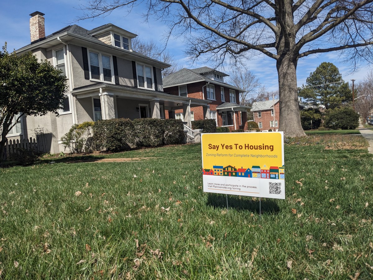 A sign in a front yard that supports housing changes.