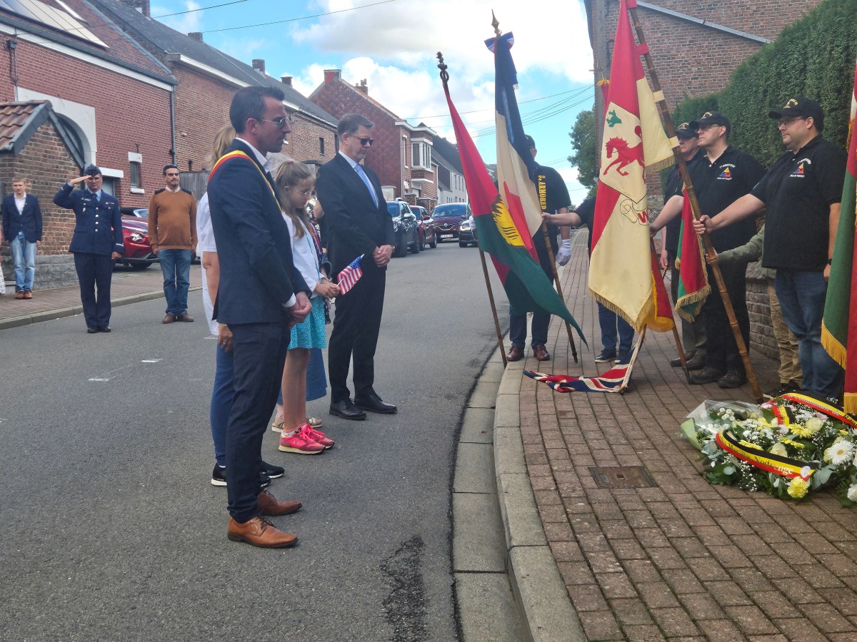 The Mayor of the Commune of Ramillies, Jean-Jaques Mathy, stands before the memorial to Ralph Nimmo. In the dark suit on the right is Lawrence Lane from the U.S. Embassy. Photo by Dylan Carter.